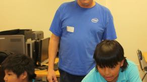 Chandler volunteer Don Wilde spends his spare time promoting FIRST Lego&copy; League Robotics competitions. Don recruits and trains team mentors from Intel and helps start new teams across the state. Here he&rsquo;s helping a student from the Salt River Pima Indian Community program his robot.