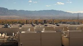Rooftop view from Fab 11X overlooking central utility building, cooling towers, Rio Grande Valley, Albuquerque and Sandia & Monzano Mountains.